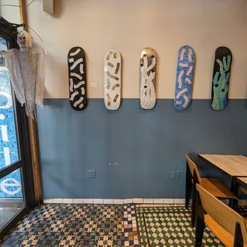 Bite - a row of skateboards mounted on a wall - Salad Near Me - New York, New York