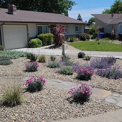 Scape Aesthetics - This xeriscape features a flagstone walkway from the sidewalk to front porch, various drought-tolerant perennials, and river rock.