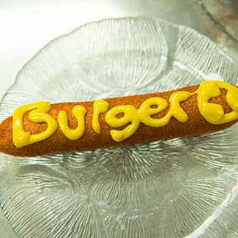 Burger World - a hot dog covered in mustard - Hot Dogs Near Me - North Bay, Ontario