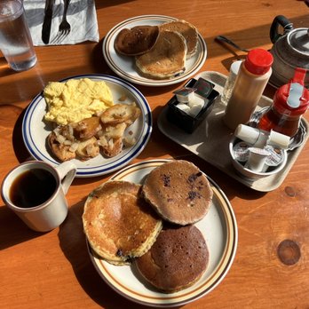 Polly's Pancake Parlor - Pancakes in foreground: buckwheat w/ chocolate chips (upper right), gingerbread (bottom), and cornmeal with blueberries (left). - Breakfast & Brunch Near Me - Sugar Hill, New Hampshire Polly's Pancake Parlor - Pancakes in foreground: buckwheat w/ chocolate chips (upper right), gingerbread (bottom), and cornmeal with blueberries (left). - Breakfast & Brunch Near Me - Sugar Hill, New Hampshire
