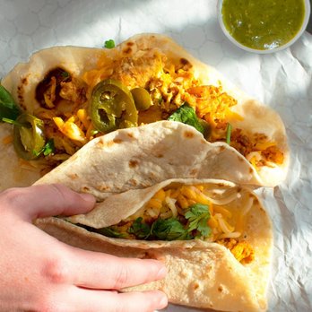 Laredo Taco Company - a hand holding a taco - Tacos Near Me - Dayton, Texas Laredo Taco Company - a hand holding a taco - Tacos Near Me - Dayton, Texas