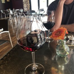 a man sitting at a table with a glass of wine a man sitting at a table with a glass of wine