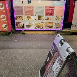 a menu board on the sidewalk