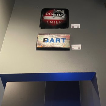 Mini Bar SF - a man standing in front of a bar sign - Lounges Near Me - San Francisco, California