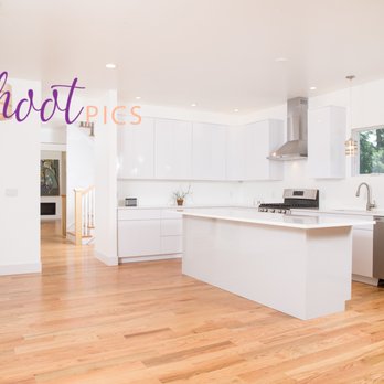 Hudson Abode - a kitchen with white cabinets and wood floors - General Contractors Near Me Hudson Abode - a kitchen with white cabinets and wood floors - General Contractors Near Me