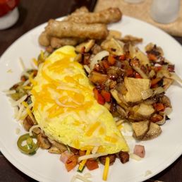 an omelet, sausages, potatoes, and hash browns
