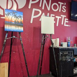 Pinot's Palette - The stage with an example of the finished painting, and the blank canvas they use to show you each step.