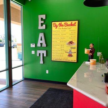 By The Bucket - a green wall with a sign that says eat - Italian Near Me - Phoenix, Arizona