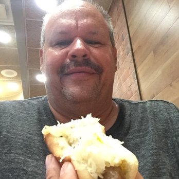 Sheetz - a man holding a hot dog in his hand - Convenience Stores Near Me - Butler, Pennsylvania