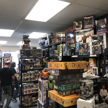 Spieda Games - Inside of half the little store. - A store interior filled with shelves of collectibles, board games, and toys, including Funko figures and boxed games, with customers browsing. - Tabletop Games Near Me - Springfield, Virginia