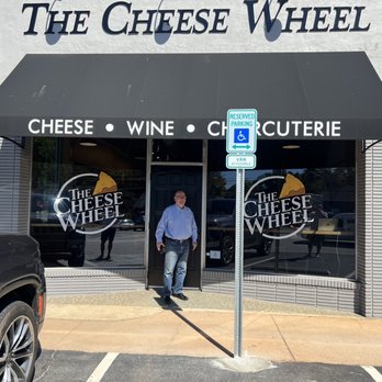 The Cheese Wheel - a man standing in front of the cheese wheel - Cheese Shops Near Me - Greenville, South Carolina The Cheese Wheel - a man standing in front of the cheese wheel - Cheese Shops Near Me - Greenville, South Carolina