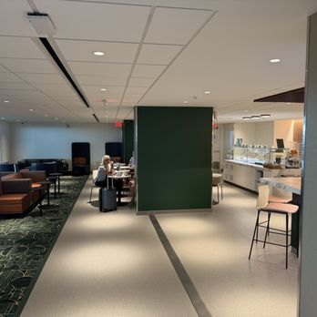 Escape Lounge - Main seating area and view of the self-serve food options. - Airport Lounges Near Me - Tulsa, Oklahoma