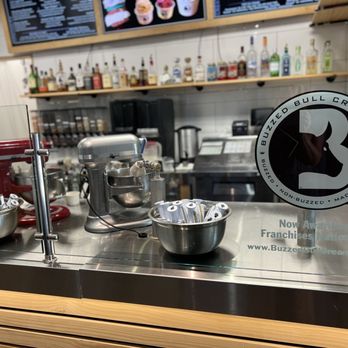 Buzzed Bull Creamery - Maineville - a counter with bowls and mixers - Ice Cream & Frozen Yogurt Near Me - Maineville, Ohio