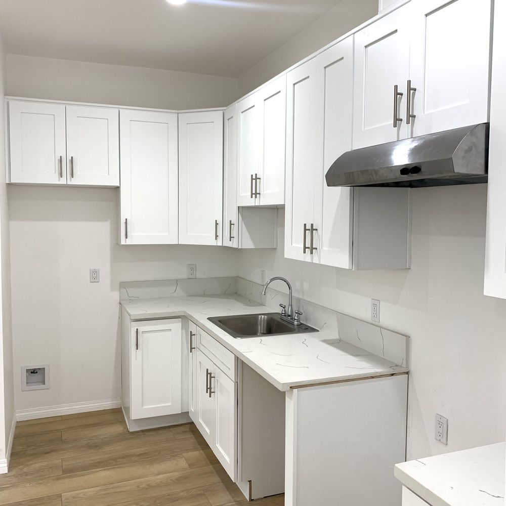 LA Developing - an empty kitchen with white cabinets - General Contractors Near Me