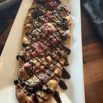 RusTeak - Black and Blue Flatbread: flatbread with shaved prime rib, blue cheese, garlic cilantro, pickled red onion, and balsamic glaze - New American Near Me - Ocoee, Florida