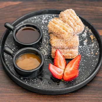 Comalito - Churros
coated with cinnamon and sugar and served with chocolate and caramel syrup - Comfort Food Near Me - Redwood City, California Comalito - Churros
coated with cinnamon and sugar and served with chocolate and caramel syrup - Comfort Food Near Me - Redwood City, California
