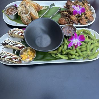 Hideout - Sampler Platter if Edamame with chili sauce on side, ahi poke tacos, kalua egg rolls, and pork belly Brussels sprouts. - Bars Near Me - Honolulu, Hawaii
