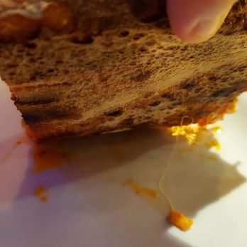 Robert's Pizza and Dough - Under side of pizza slice showing char - Pizza Near Me - Chicago, Illinois Robert's Pizza and Dough - Under side of pizza slice showing char - Pizza Near Me - Chicago, Illinois