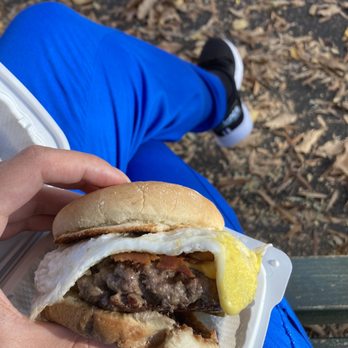 Burger One - a person sitting on a park bench - Burgers Near Me - New York, New York