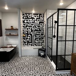 Traditional Floors & Design Center - Modern bathroom display with Bain Ultra Tub. Large and small tiles on the walls.