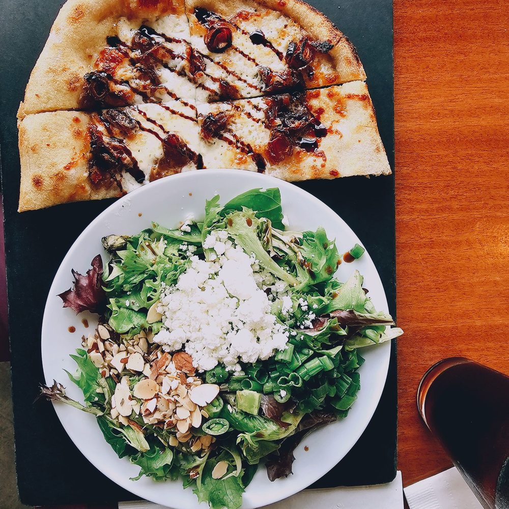 Half pizza with mozzarella, chopped dates and balsamic reduction. Fresh greens salad