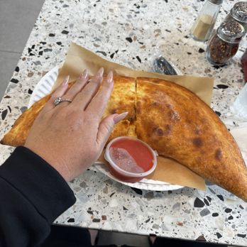 Upper East Slice - Look at the size of this calzone and I have huge hands - Pizza Near Me - Temecula, California