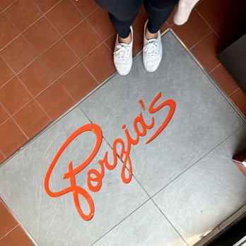 Porzia’s - a woman standing in front of a sign - Italian Near Me - Toronto, Ontario