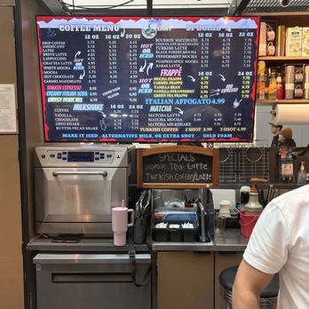 Cath Coffee - Menu - A digital menu board at a coffee kiosk shows various coffee, specialty drinks, and Italian affogato options with prices, including hot, iced, and frappé beverages. - Coffee & Tea Near Me - Indianapolis, Indiana
