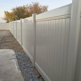 Tan vinyl fence in the back yard.