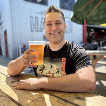 The Hangar - a man holding a glass of beer - Beer Bar Near Me - Falcon Heights, Minnesota