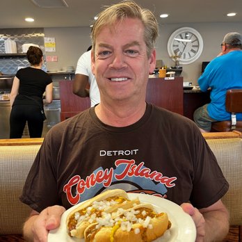 L Georges Coney Island - a man holding a plate of hot dogs - Breakfast & Brunch Near Me - Walled Lake, Michigan