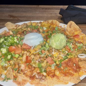 Yard House - Chicken Nachos : pinto beans, cheddar, Monterey Jack, tomatoes, cilantro, onions, crushed avocado, sour cream and more - New American Near Me - Washington, DC, District of Columbia