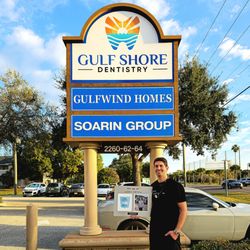 A picture of Dr. Mike holding his Top Dentist Award in front of our sign!