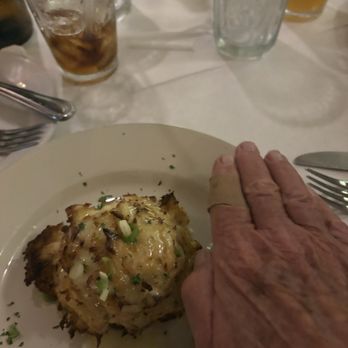 Angie's Seafood - Crab cake with adult hand for perspective - Seafood Near Me - Baltimore, Maryland