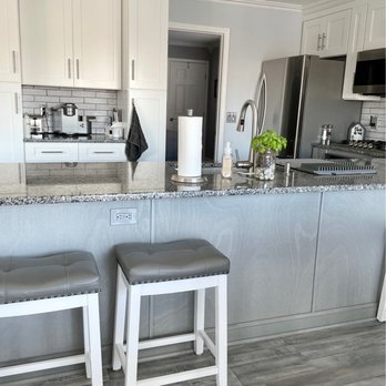 Csd Kitchen Bath Ja - Kitchen featuring white cabinets, granite countertops, stainless steel refrigerator, and a gray backsplash with subway tiles. - General Contractors Near Me - Brick, New Jersey