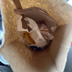 A bacon egg & cheese biscuit sitting on a wrapper in the bag.