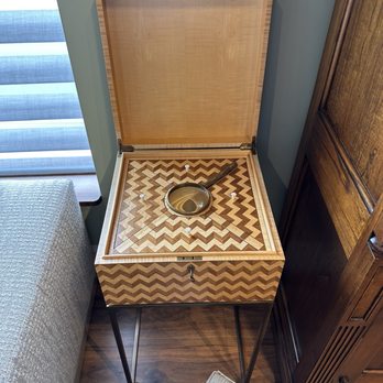 Designer's Studio - Interesting piece in their show room - A wooden music box with a chevron pattern on its surface, open to reveal a metal arm and a circular component inside. - Interior Design Near Me - Centre Hall, Pennsylvania