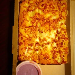 a pizza in a box with a cup of sauce a pizza in a box with a cup of sauce