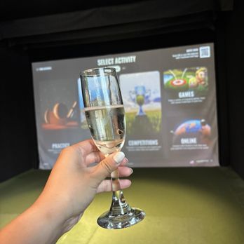 Five Iron Golf - Welcome champagne and game screen - Golf Near Me - Chicago, Illinois
