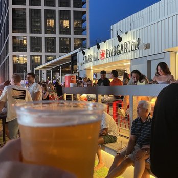 Starr Hill Biergarten - a person holding a glass of beer - Beer Gardens Near Me - Tysons, Virginia