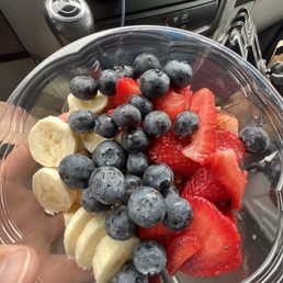Acia bowl strawberries, bananas, blueberries, honey and granola