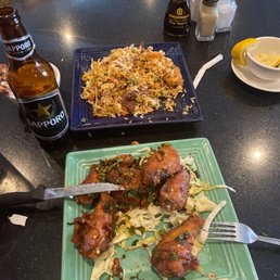 two plates of food and a bottle of beer