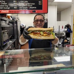 Owner; smiling with a large chorizo egg & cheese Owner; smiling with a large chorizo egg & cheese