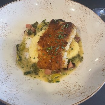Restaurant Lola - Herb encrusted cod on a bed of grits with bacon pieces. - New American Near Me - Bremerton, Washington Restaurant Lola - Herb encrusted cod on a bed of grits with bacon pieces. - New American Near Me - Bremerton, Washington