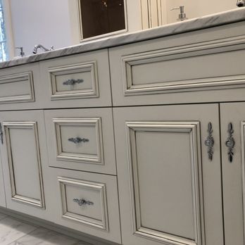 Axe Construction - a kitchen with white cabinets and marble countertops - General Contractors Near Me Axe Construction - a kitchen with white cabinets and marble countertops - General Contractors Near Me