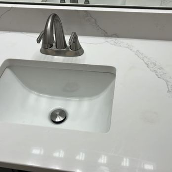 Remodel With Us - a bathroom sink and mirror - General Contractors Near Me