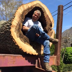 Butler Tree Service - Billy Butler of Butler Tree Services sitting inside a tree trunk.