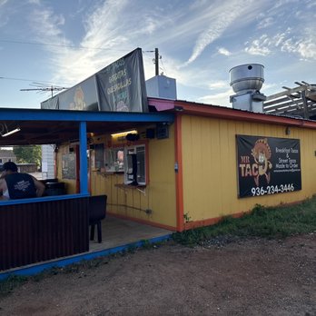 Mr Tacos - a man sitting at a table in front of a restaurant - Food Stands Near Me - Mount Enterprise, Texas