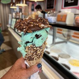 a hand holding a cone of ice cream a hand holding a cone of ice cream
