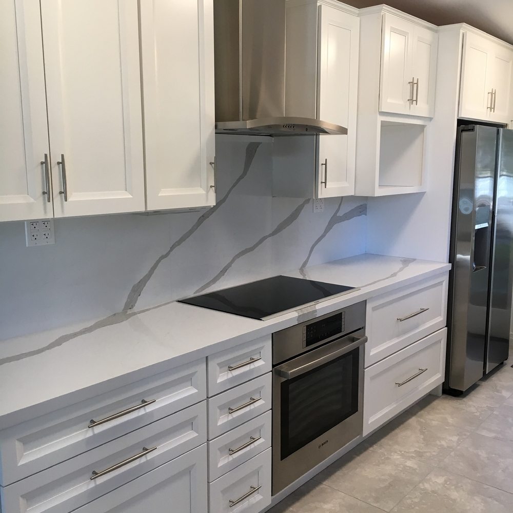 ZV Construction - a kitchen with white cabinets and stainless steel appliances - Flooring Near Me - Napa, California